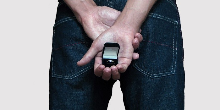 Парень держит подарок для девушки за спиной