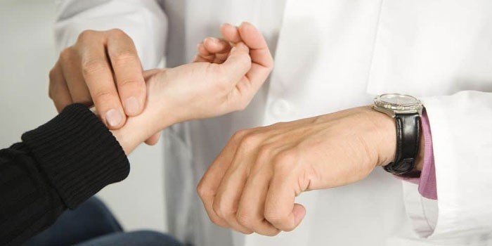 Врач измеряет пульс у пациента