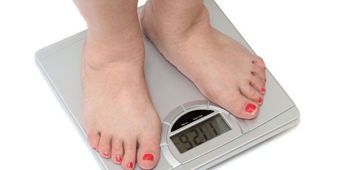 Женщина стоит на напольных весах