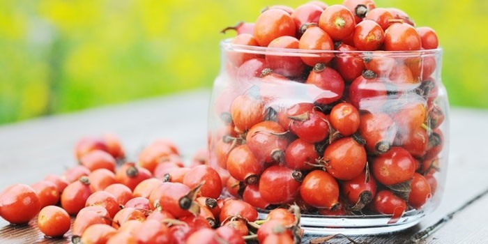 Плоды шиповника в стеклянном сосуде