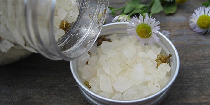 Банка и миска со льдом и ромашка