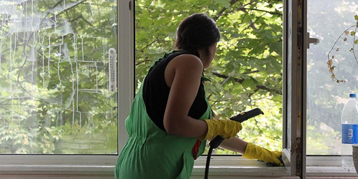 Женщина чистит окна