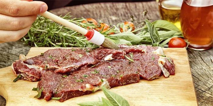 Мясо смазывают маринадом