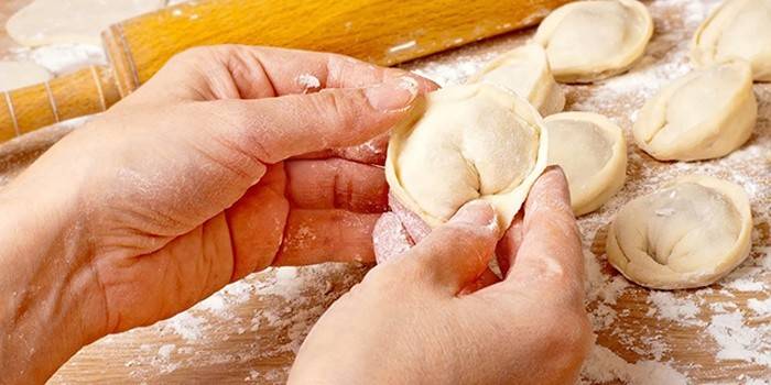 Девушка лепит пельмени