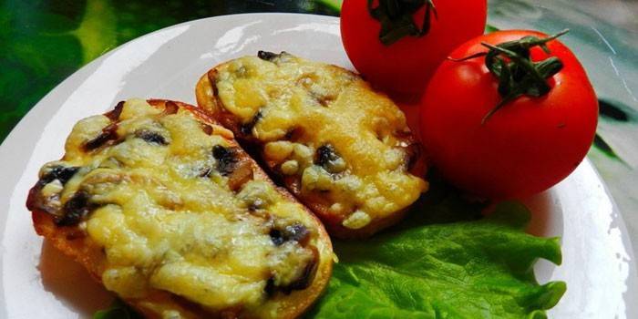 Горячие бутерброды с грибами и сыром на тарелке с помидорами
