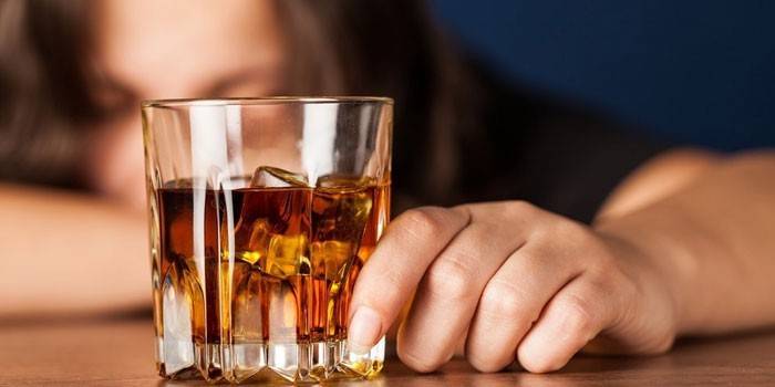 Стакан виски в руке у женщины