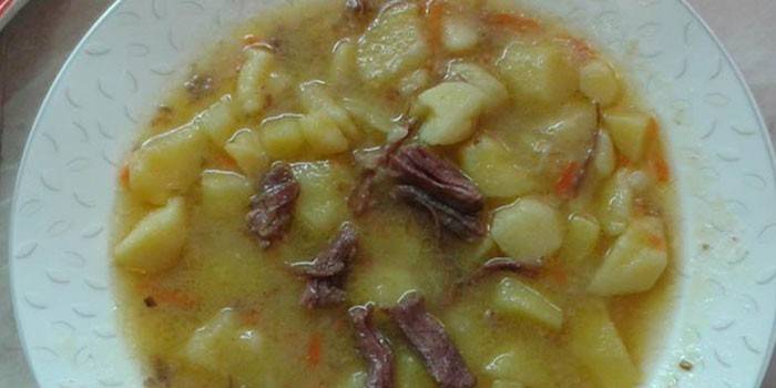 Тушеный картофель с тушенкой в тарелке