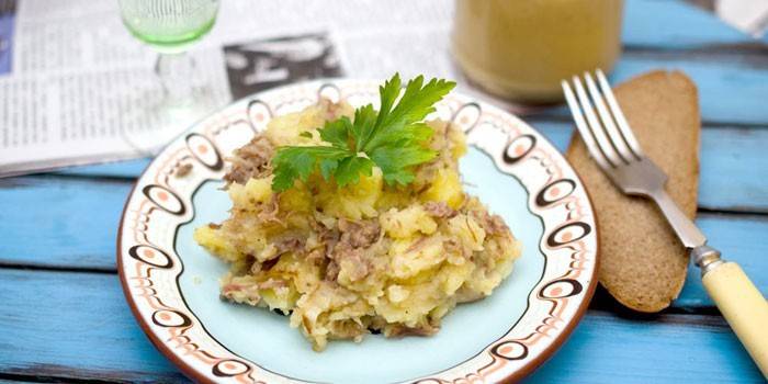 Картофельное пюре с тушенкой на тарелке