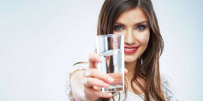 Девушка протягивает стакан воды