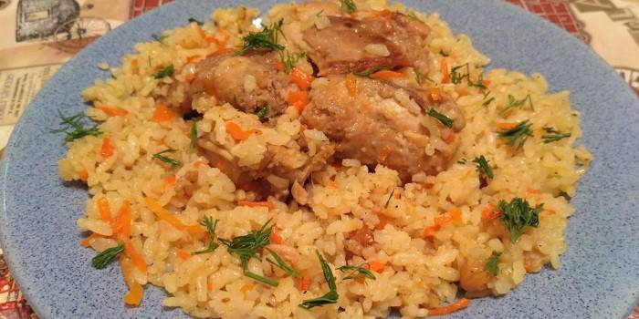 Готовый плов с мясом кролика на тарелке
