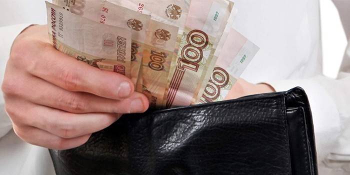 Мужчина достает деньги из бумажника