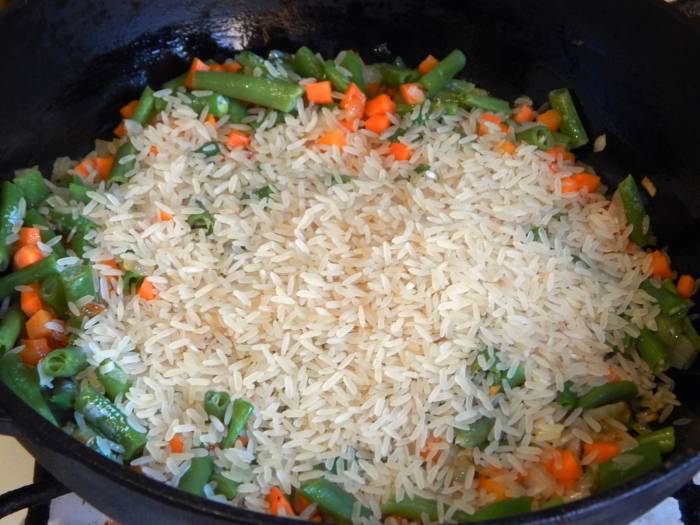 Добавление риса в сковороду с овощами