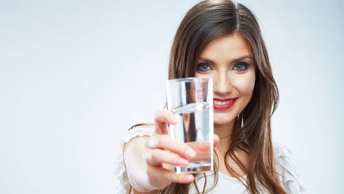 Женщина держит стакан с водой