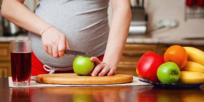 Девушка на 8 месяце беременности режет фрукты