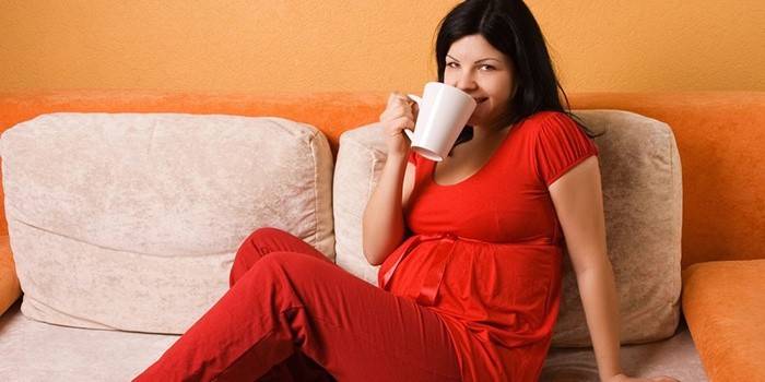 Беременная девушка пьет какао
