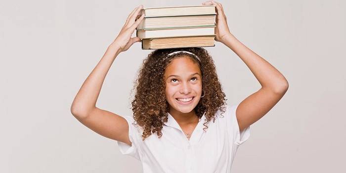 Девушка носит книги на голове для похудения лица