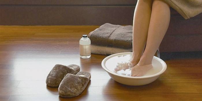 Женщина принимает ванночку для ног