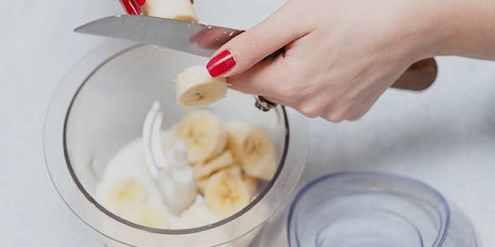 Девушка режет банан