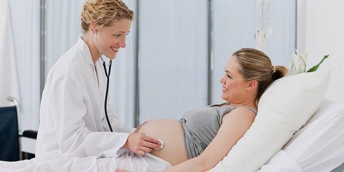 Доктор прослушивает беременную девушку