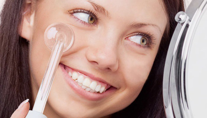 Девушка использует дарсонваль для лица