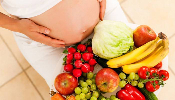 Беременная женщина с овощами и фруктами