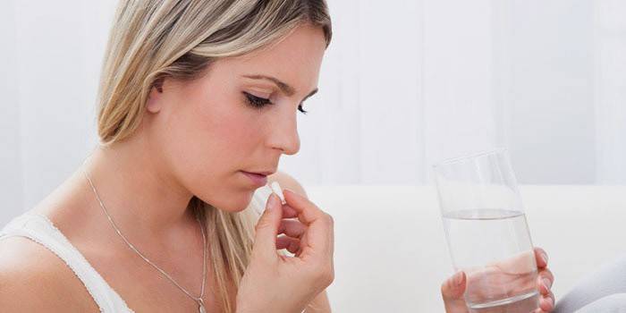 Женщина пьет препарат для выведения токсинов