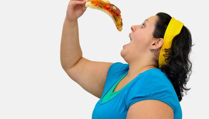 Полная девушка ест пиццу