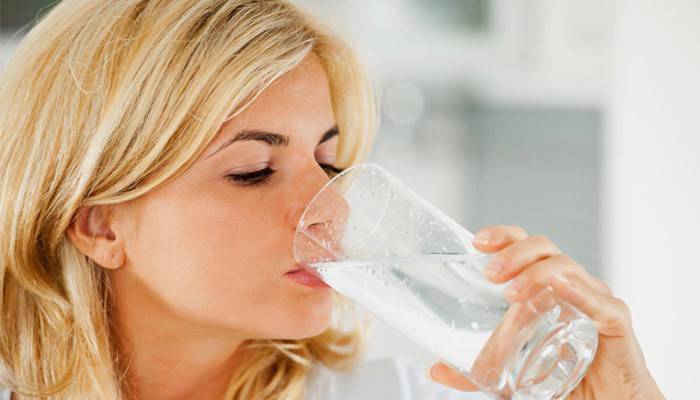 Женщина пьет воду с содой для очищения организма