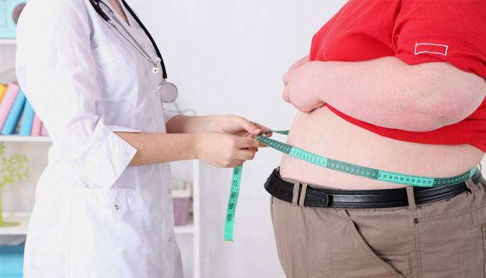 Врач измеряет объем живота пациента с ожирением