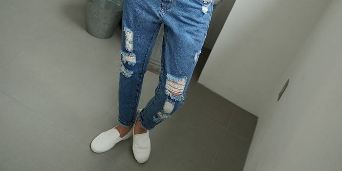 Рваные и потертые джинсы на девушке