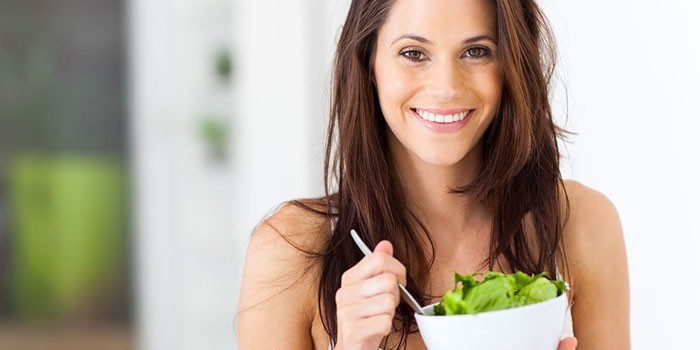 Девушка держит тарелку с салатом