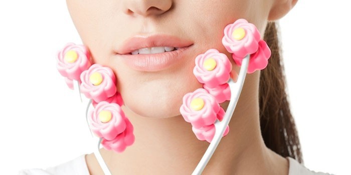 Девушка делает массаж лица массажером