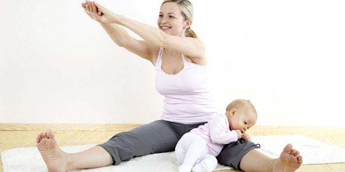 Молодая мама делает упражнения с ребенком