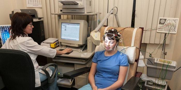 Девушке делают компьютерную электроэнцефалографию головного мозга