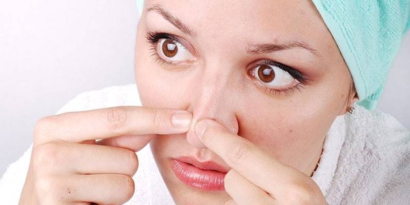 Женщина чистит кожу на носу