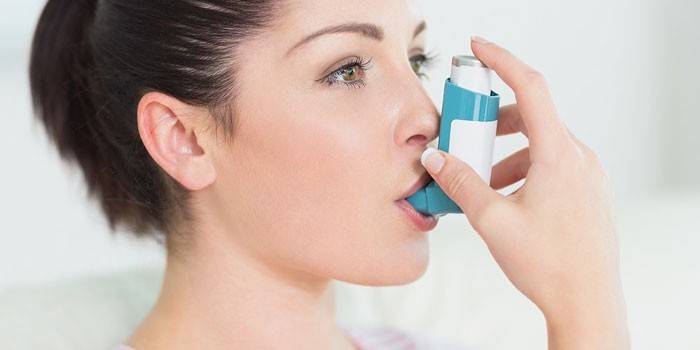 Девушка с ингалятором от астмы во рту