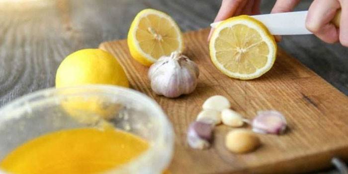 Женщина режет лимон и чеснок
