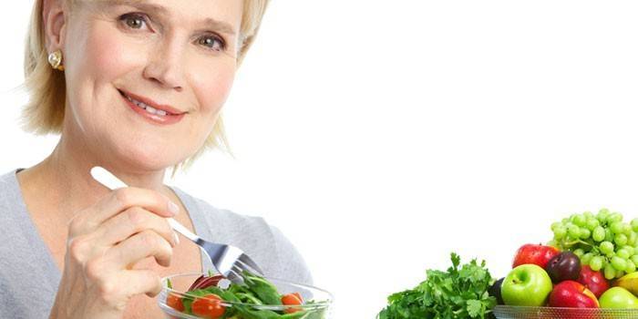 Женщина держит в руках тарелку с салатом
