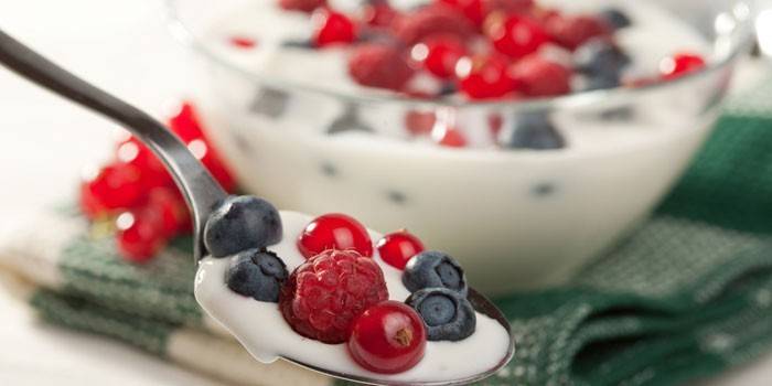 Йогурт со свежими ягодами в ложке и миске