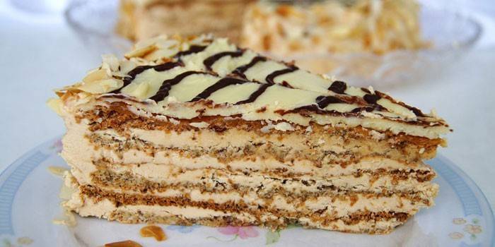 Кусочек торта Эстерхази с кремом из вареной сгущенки на тарелке