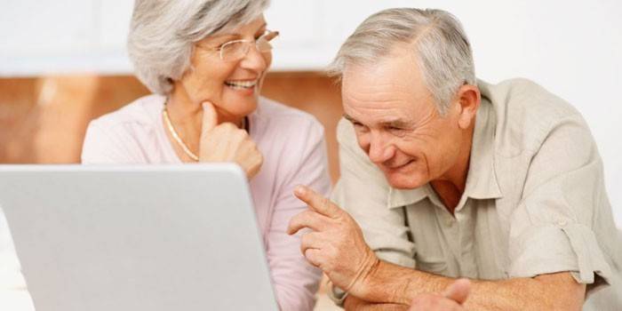 Пожилые мужчина и женщина с ноутбуком