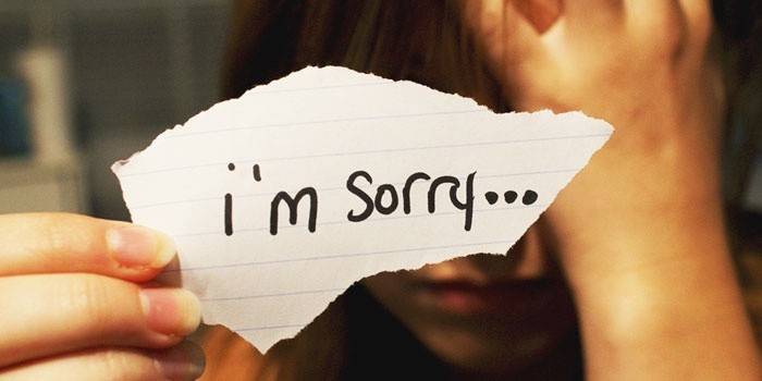 Девушка с запиской "Я извиняюсь"