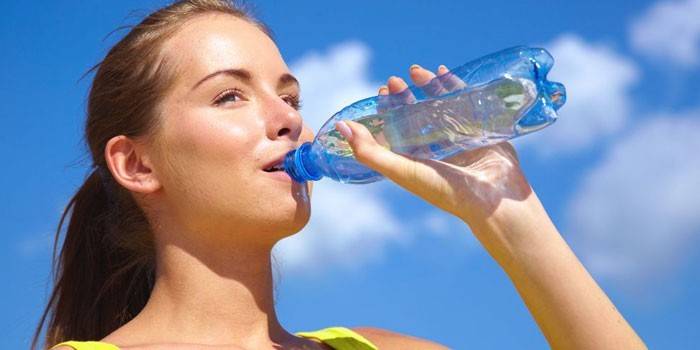 Девушка пьет воду из бутылки