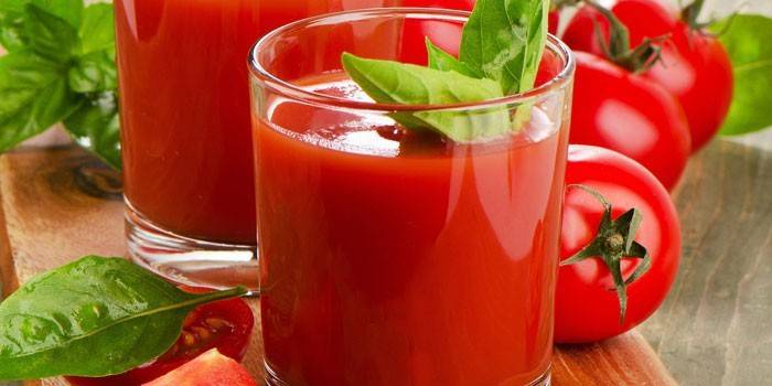 Томатный сок в стакане и помидоры