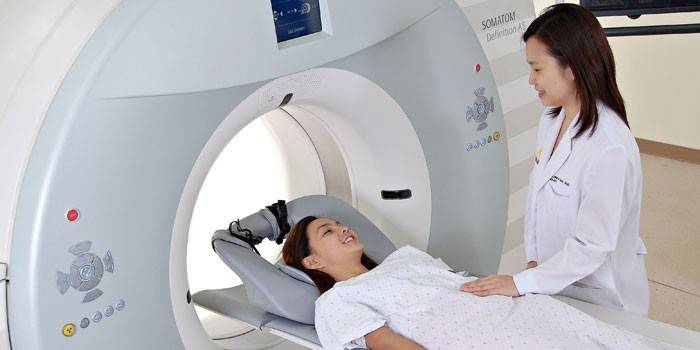 Девушка в томографе беседует с врачом перед исследованием 