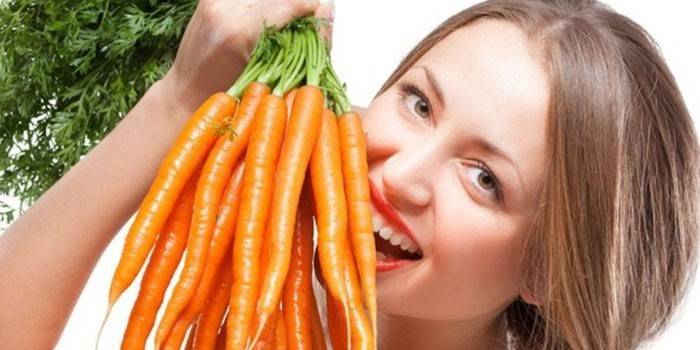 Девушка держит пучок моркови