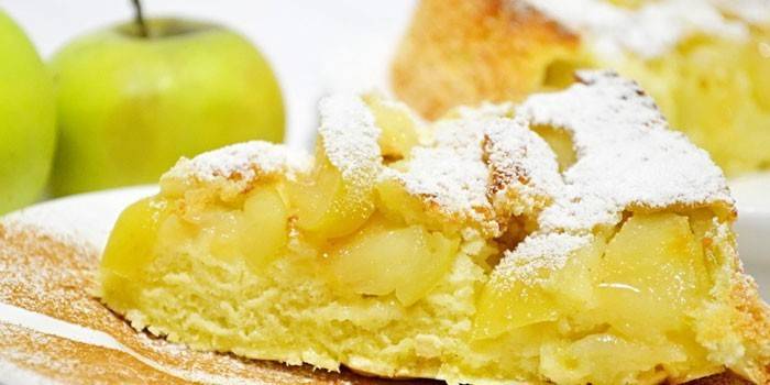 Кусочек бисквитного пирога с яблоками на тарелке