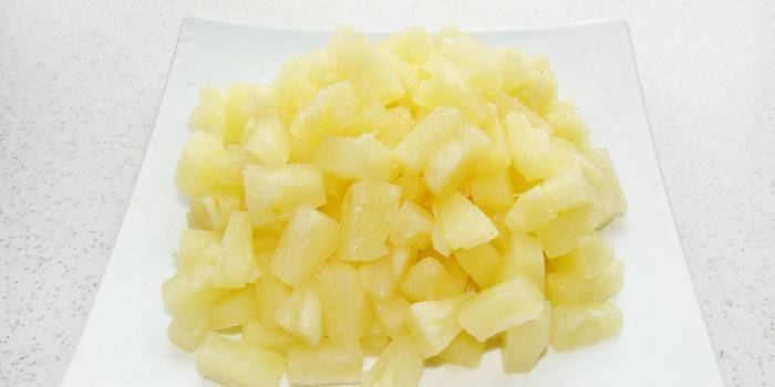 Кусочки консервированных ананасов на тарелке