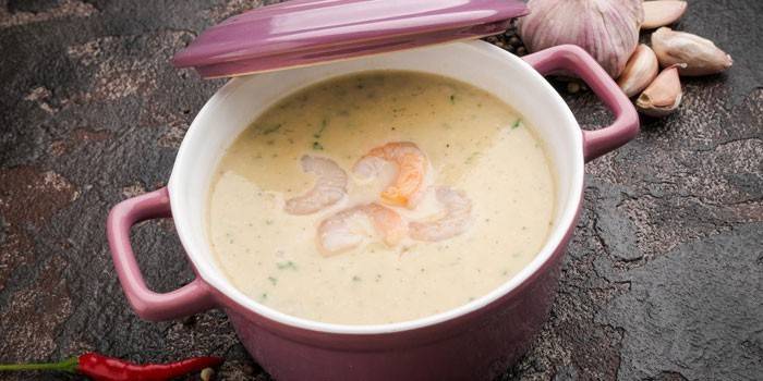 Чесночный крем-суп с креветками в тарелке