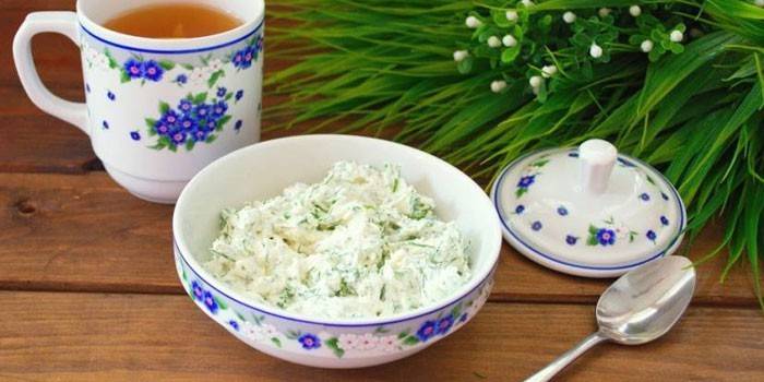 Творожная масса с зеленью в тарелке и чашка чая
